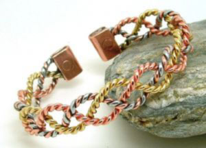 A lovely delicate design made from light twists of copper and brass laced together with enough aluminum to give a three colour look. The lace ends in two copper tabs each fitted with rare earth magnets 